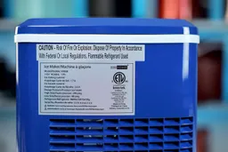 A sticker on a countertop ice maker showing technical information and a caution about risks and a notice for proper disposal.