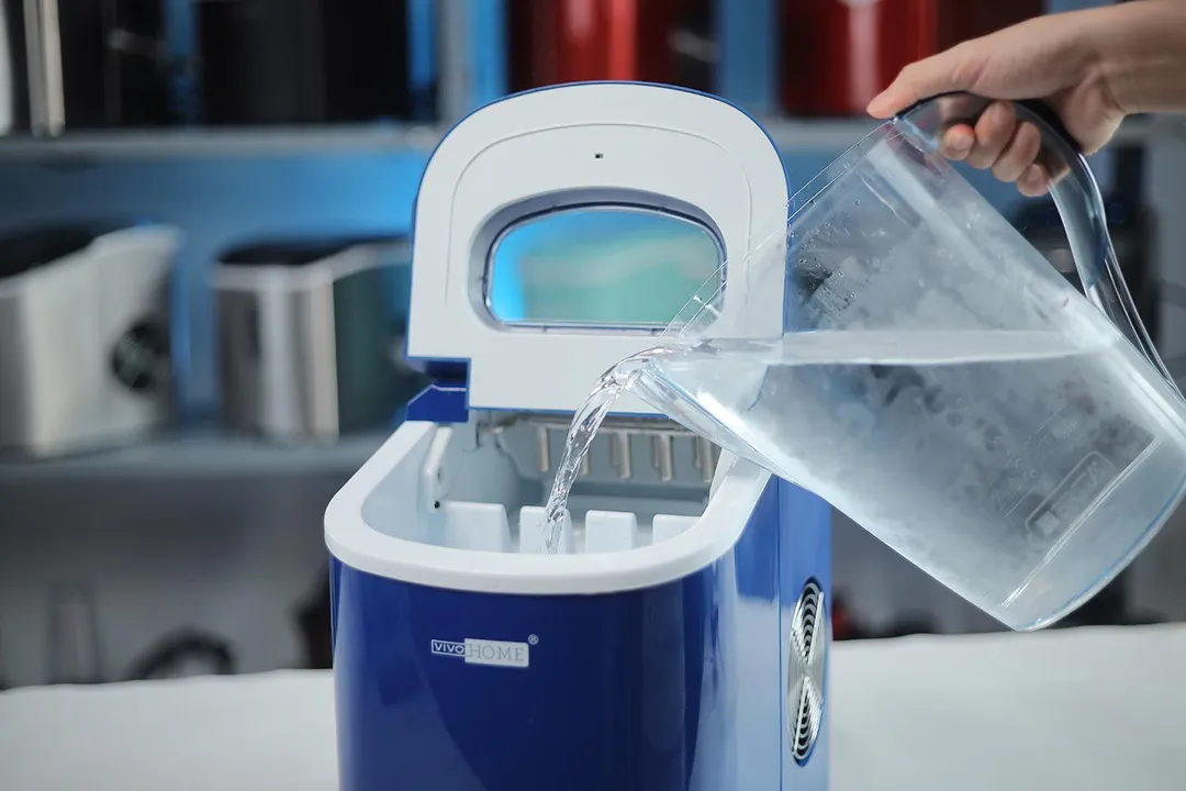 Water being poured from a jug into the Vivo Home portable ice maker.