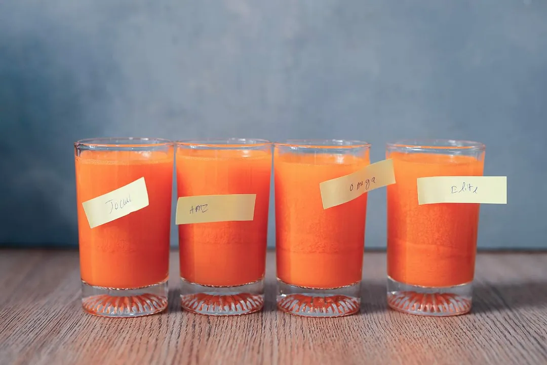 Four glasses of carrot juice with labels on them