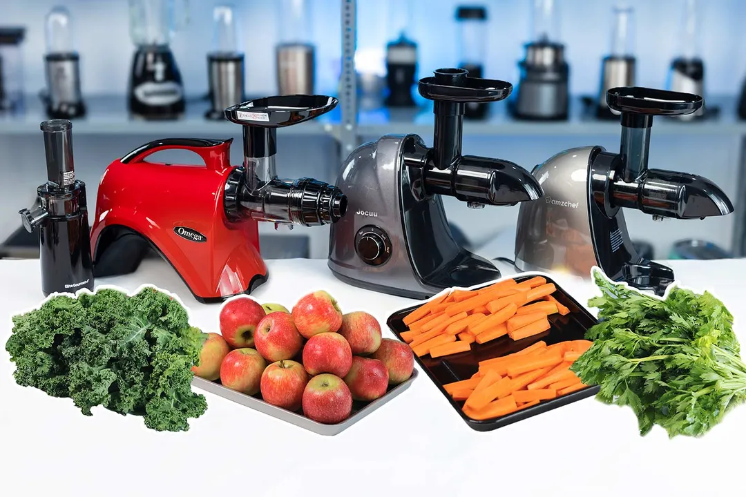 Carrots, kale, apples, and celery on the table with different masticating juicer models