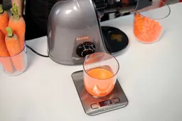 Weighing carrot juice made with the Jocuu masticator