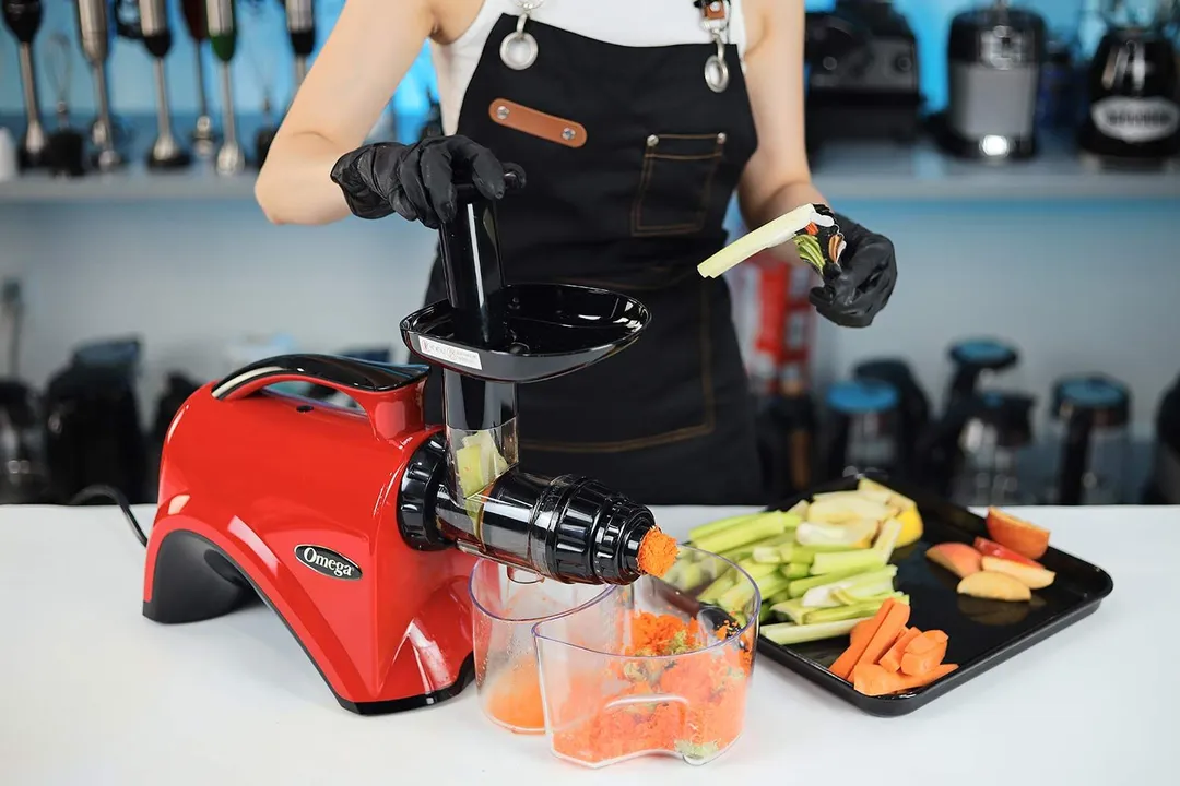 Person juicing different ingredients with the Omega masticator