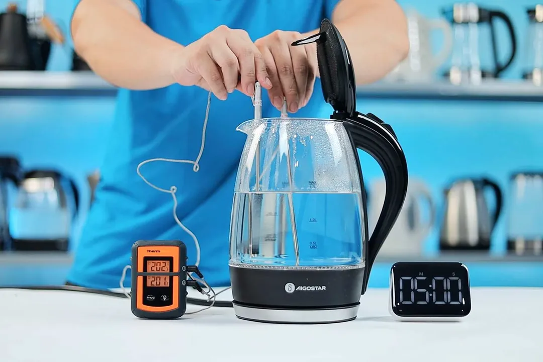 On the right is a Thermo Pro two-probe digital thermometer displaying 201°F and 202°F. In the middle is the Aigostar Electric Kettle 300104LCB with 1.5 liters of water and two probes inside. On the right is a digital timer on a 5 minute countdown.