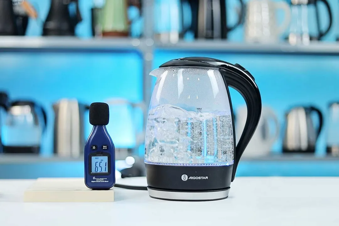 The Aigostar Electric Kettle 300104LCB is boiling 1.5 liters of water. The noise meter displays the maximum sound pressure level to be 65.1 dB.