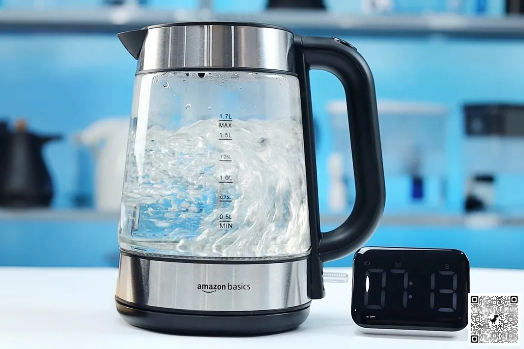 1.5 liter of water boiling inside the Amazon Basics Electric Glass and Steel Kettle (F-625C). The digital timer displays 7 minutes and 13 seconds.