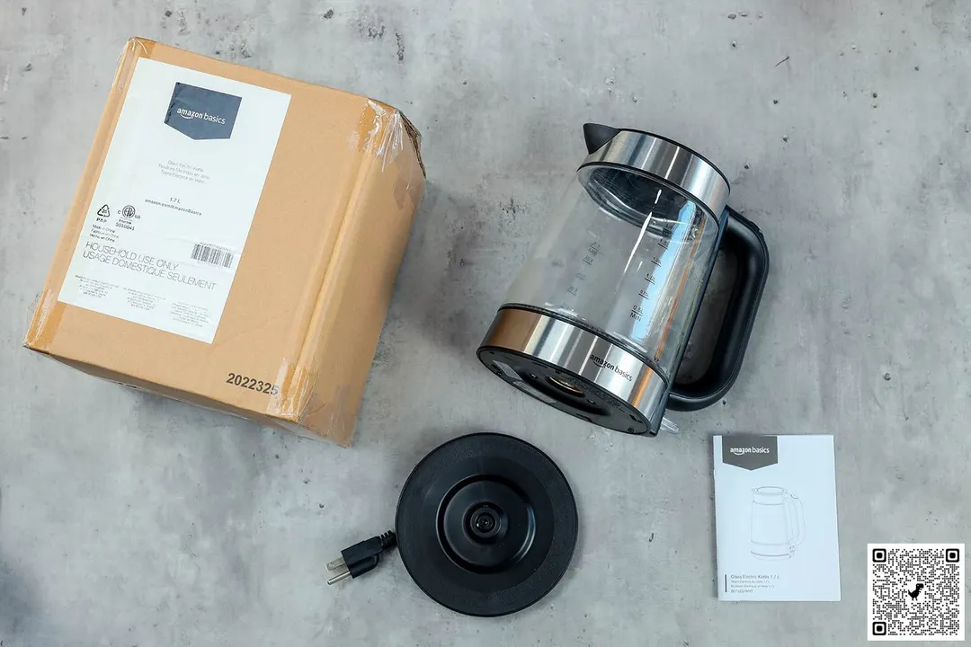 On the upper right is the Amazon Basics Electric Glass and Steel Kettle (F-625C). On the left is a cardboard box. Below the kettle, on the right is an instruction manual and on the left is the power base.