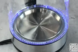The heating plate with a LED ring around it glowing blue of the Amazon Basics Electric Glass and Steel Kettle (F-625C).