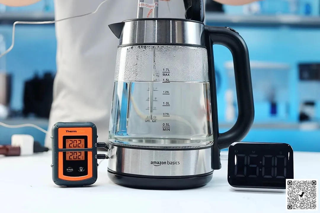 On the right is a Thermo Pro two-probe digital thermometer displaying 202°F for both probes. In the middle is the Amazon Basics Electric Glass and Steel Kettle (F-625C) with 1.5 liters of water and two probes inside. On the right is a digital timer displaying 5 minutes on the countdown.