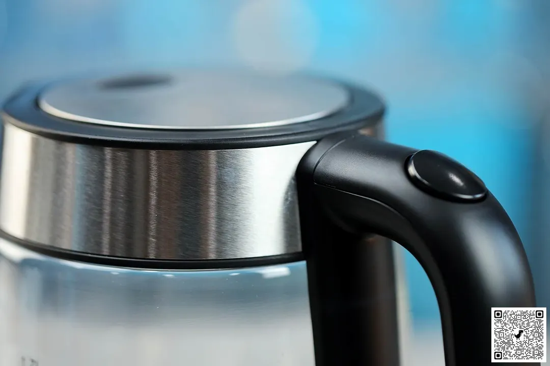 The button for the pop-up lid of the Amazon Basics Electric Glass and Steel Kettle (F-625C).