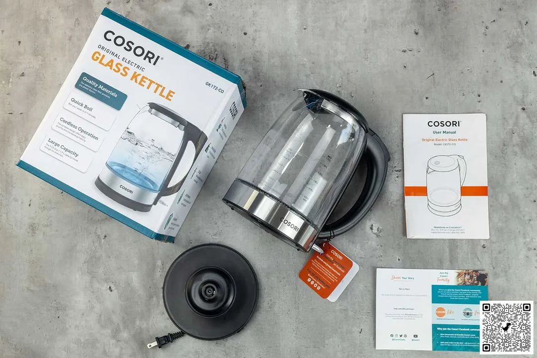 On the upper left is the box of the Cosori Glass Electric Kettle (GK172-CO). In the middle is the carafe. On the right are two documents. Below the carafe is the power base.