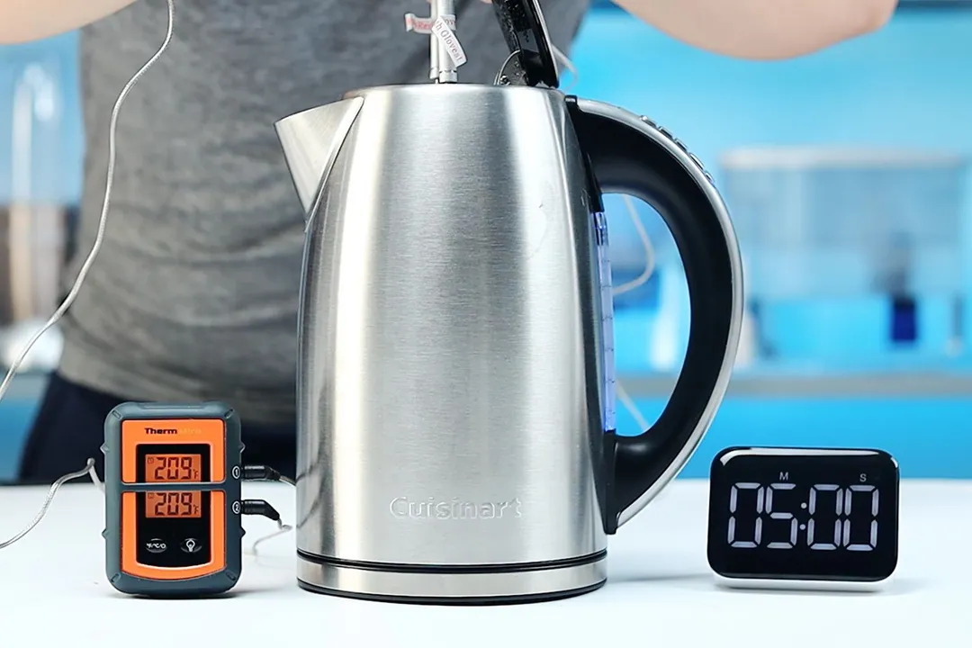 On the right is a Thermo Pro two-probe digital thermometer displaying 209°F for both probes. In the middle is the Cuisinart Stainless Steel Electric Kettle with 6 Preset Temperatures (CPK-17P1 PerfecTemp) with 1.5 liters of water and two probes inside. On the right is a digital timer displaying 5 minutes on the countdown.