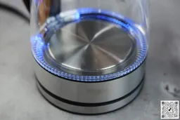 The heating plate with a LED ring around it glowing blue of the Elite Gourmet Electric Glass Kettle (EKT-602).