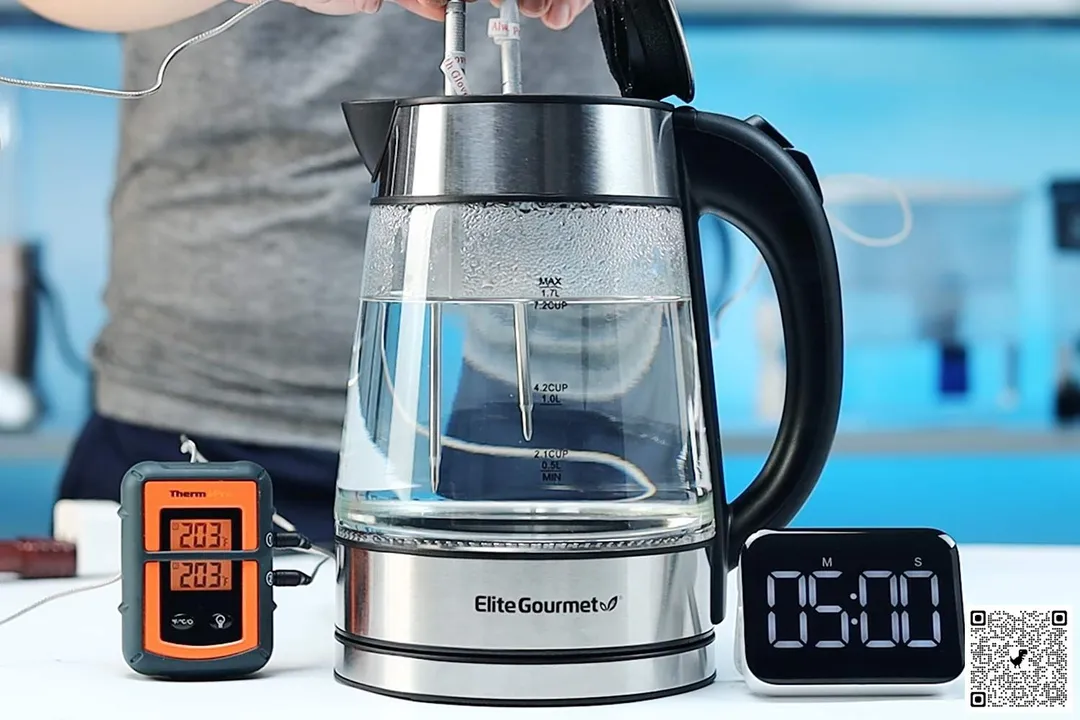 On the right is a Thermo Pro two-probe digital thermometer displaying 203°F for both probes. In the middle is the Elite Gourmet Electric Glass Kettle (EKT-602) with 1.5 liters of water and two probes inside. On the right is a digital timer displaying 5 minutes on the countdown