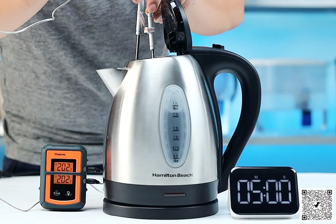 On the right is a Thermo Pro two-probe digital thermometer displaying 202°F for both probes. In the middle is the Hamilton Beach Stainless Steel Electric Kettle (40880) with 1.5 liters of water and two probes inside. On the right is a digital timer displaying 5 minutes on the countdown.