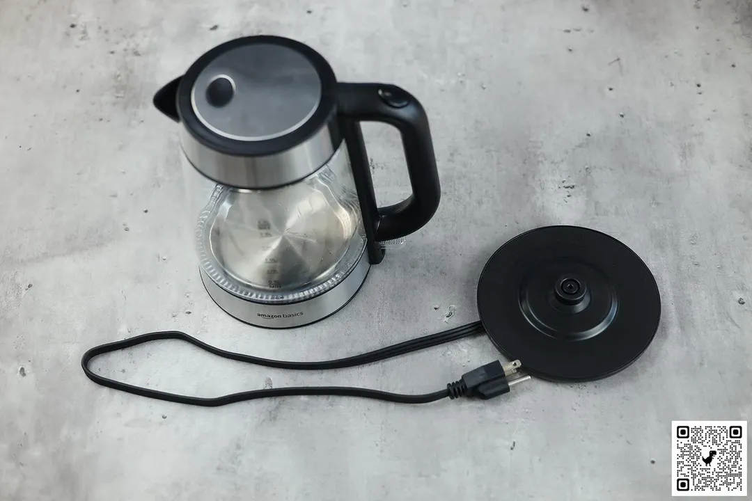 On the right is the carafe of the Amazon Basics Electric Glass and Steel Kettle (F-625C). On the left is its power base with its power cord extended from below.