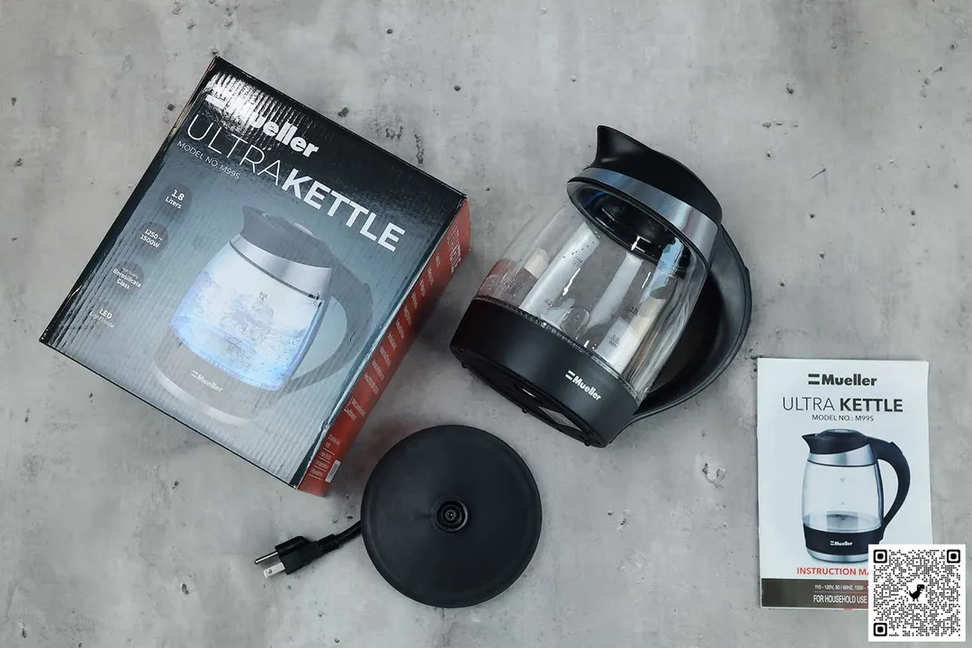 On the upper right is the Mueller Ultra Electric Kettle (M99S). On the left is a cardboard box. Below the kettle, on the right is an instruction manual and on the left is the power base.