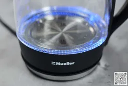 The heating plate with a LED ring around it glowing blue of the Mueller Ultra Electric Kettle (M99S).