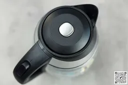 The black pop-up lid of the Mueller Ultra Electric Kettle (M99S) has a silver button in the middle.