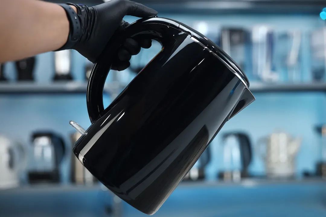A hand holding the Secura Electric Stainless Steel Double-Wall Kettle (SWK-1701DA).