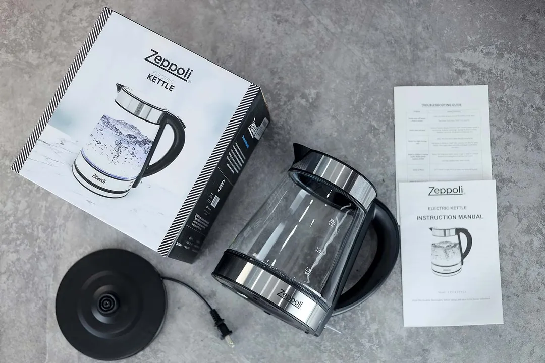 In the middle is the Zeppoli Electric Kettle ZPL-KETTLE. On the left is a cardboard box, below it is the power base. On the right is an instruction manual.