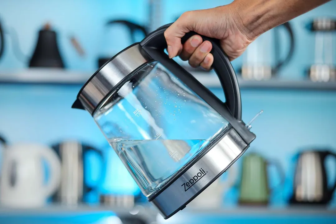 A hand holding the Zeppoli Electric Kettle ZPL-KETTLE by its handle.