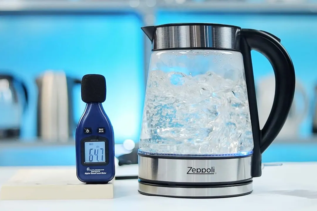 The Zeppoli Electric Kettle ZPL-KETTLE is boiling 1.5 liters of water. The noise meter displays the maximum sound pressure level to be 64.7 dB. The power meter reads 113 V, 8.125 A, 929 W, 100 Wh, 50 Hz, and 1.0 PF.