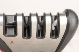 Top view of the abrasive slots of the Mueller handheld sharpener, with scissor slot, tungsten blades, diamond rods, and ceramic rods