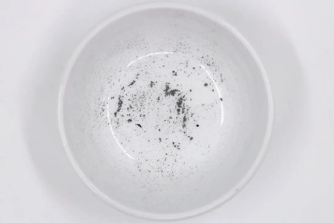 Sharpening residue as metal dust in a white bowl.