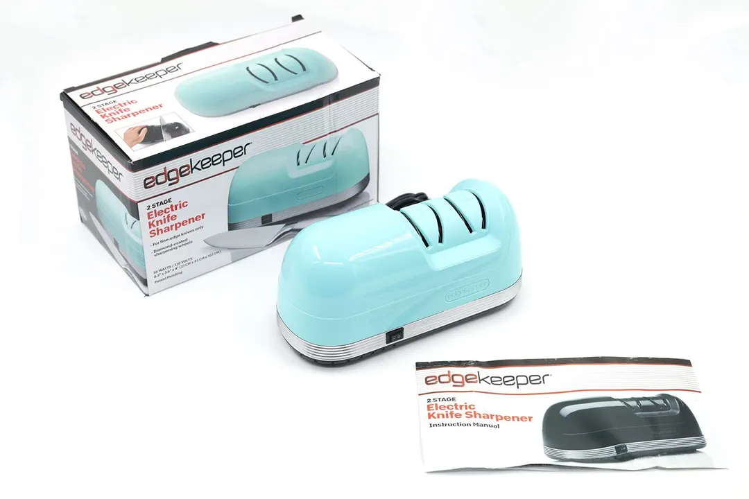 The EdgeKeeper electric knife sharpener next to its package box and instruction manual