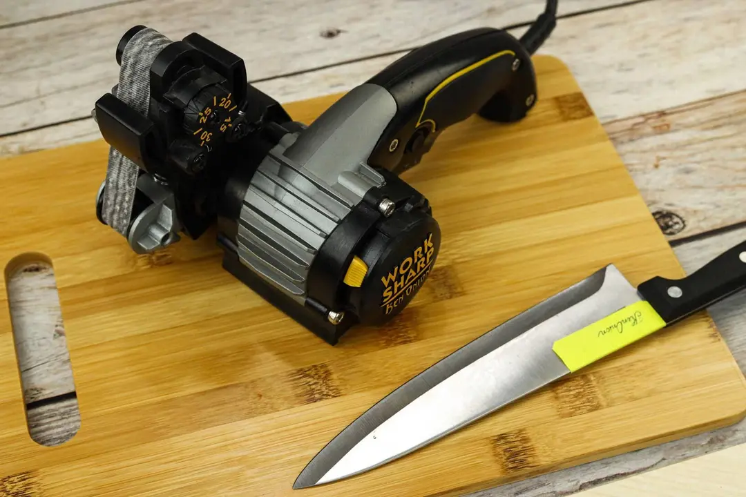 The Work Sharp Ken Onion knife sharpener next to a kitchen knife on a cutting board