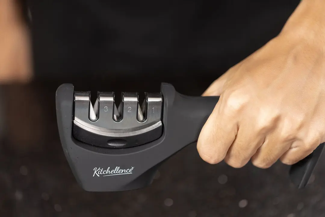 The Kitchellence knife sharpener held in one hand.