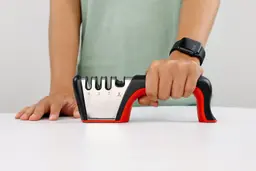Person holding the Mueller 4-stage manual knife sharpener in one hand