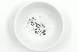 Sharpening residue as metal dust in a white bowl