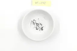 Sharpening residue as metal dust in a white bowl with a label that reads WS CPE2
