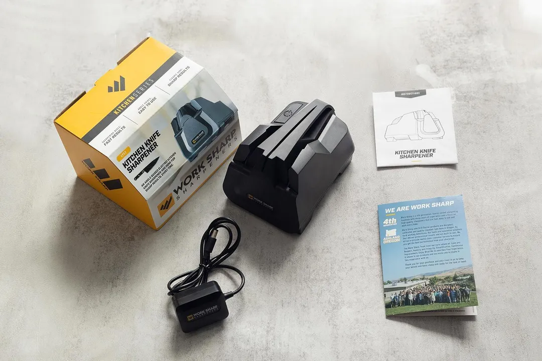 The Work Sharp E2, its power cord, package box, manual instruction leaflet, and advertisement leaflet.