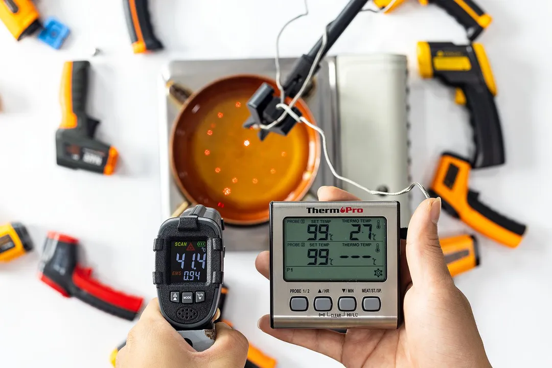 A reviewer holding the Sovarcate HS980E and using it to measure the surface temperature of a pan of hot oil. The screen reads 41.4°C.