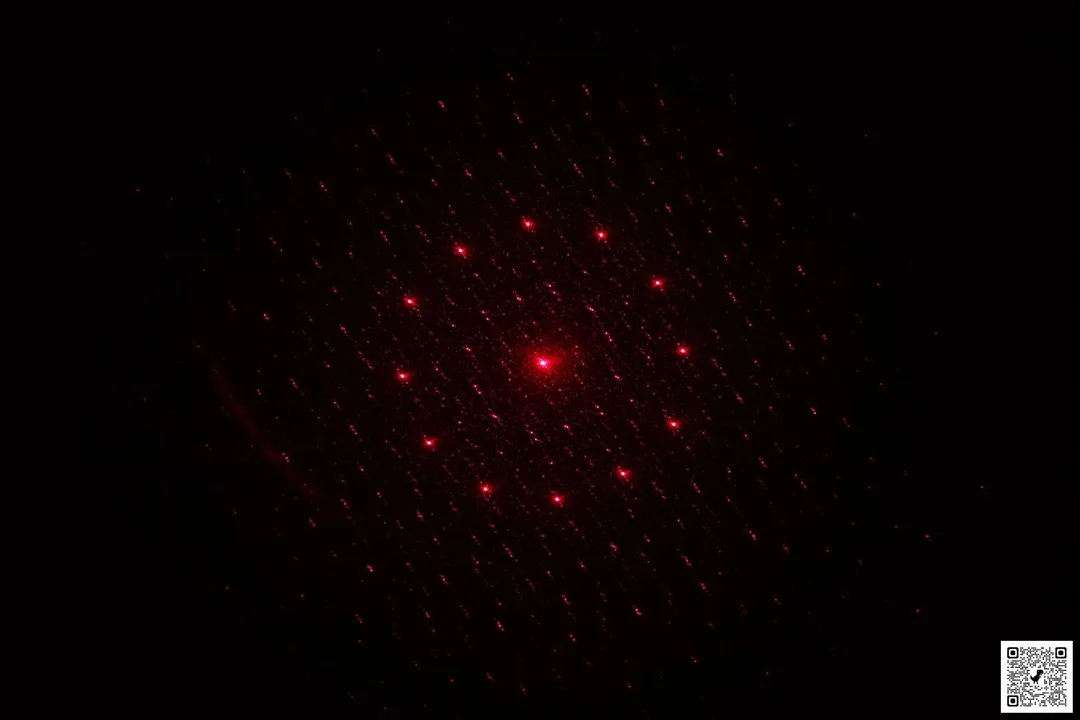 The red, 13-point pattern of the laser emitter of the Mecurate IR thermometer in a dark room.