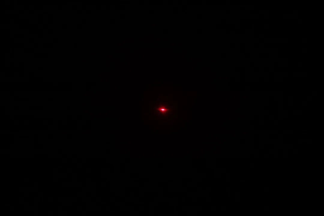 The Etekcity Lasergrip 800’s laser emitter in a dark room.