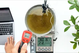 The Eventek G550 measures the temperature of a pan of hot oil from a distance of 16 inches away. The screen reads 363.3°F.