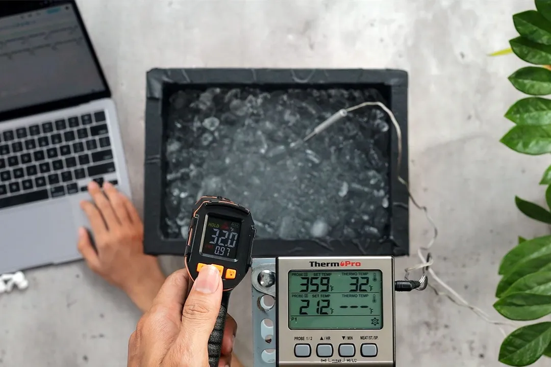 The ice-bath test is being conducted on the Mercurate IRT600A. The ice bath temperature is verified to be 32°F using a temperature probe. Temperature readings of the thermometer are entered into the laptop.