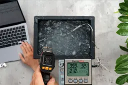 The Mecurate IRT600A is being used by a reviewer to measure the surface temperature of an ice bath. The display shows 30.7°F.