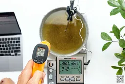 The ThermoPro TP-30 is used to scan the temperature of boiling oil in a pan from 16 inches away. The screen reads 368.4°F.