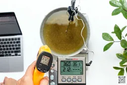 The ThermoPro TP-30 is used to scan the temperature of boiling oil in a pan from 12 inches away. The screen reads 372.2°F.