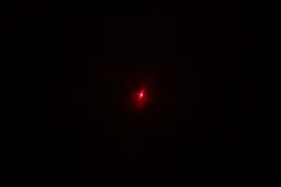 The red dot from the laser emitter of the Wintact WT530 IR thermometer in a dark room.
