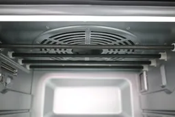 The cooking chamber ceiling of the Cuisinart TOA-60 Toaster Oven has a convection fan cavity and four nichrome heating elements. The cooking chamber also has a safety hook on the left and interior light on the right.