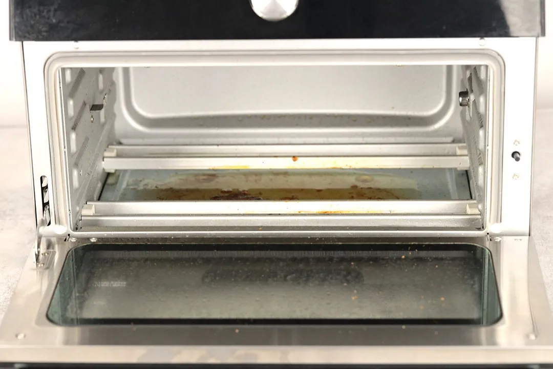 Grease on the slide-out crumb tray inside the cooking chamber of the Instant Omni Plus 18L 10-in-1 Air Fryer Toaster Oven.