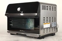 The front of a closed Instant Omni Plus 18L 10-in-1 Toaster Oven has a control panel and the right has ventilation holes.