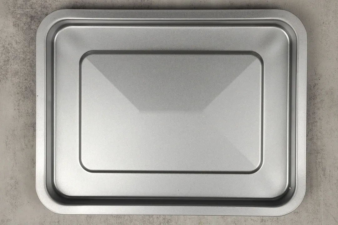 A silver baking pan of the stainless steel BLACK+DECKER CTO6335S Convection Toaster Oven on a grey background.