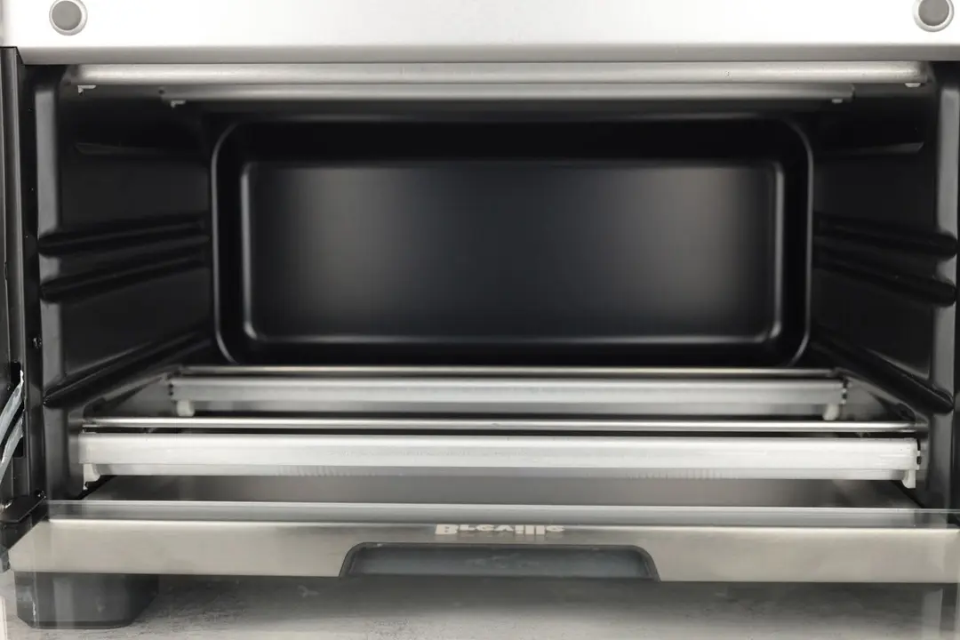 The Breville BOV450XL ’s cooking chamber is black and has 4 quartz heating elements with guards and 2 guide rails.
