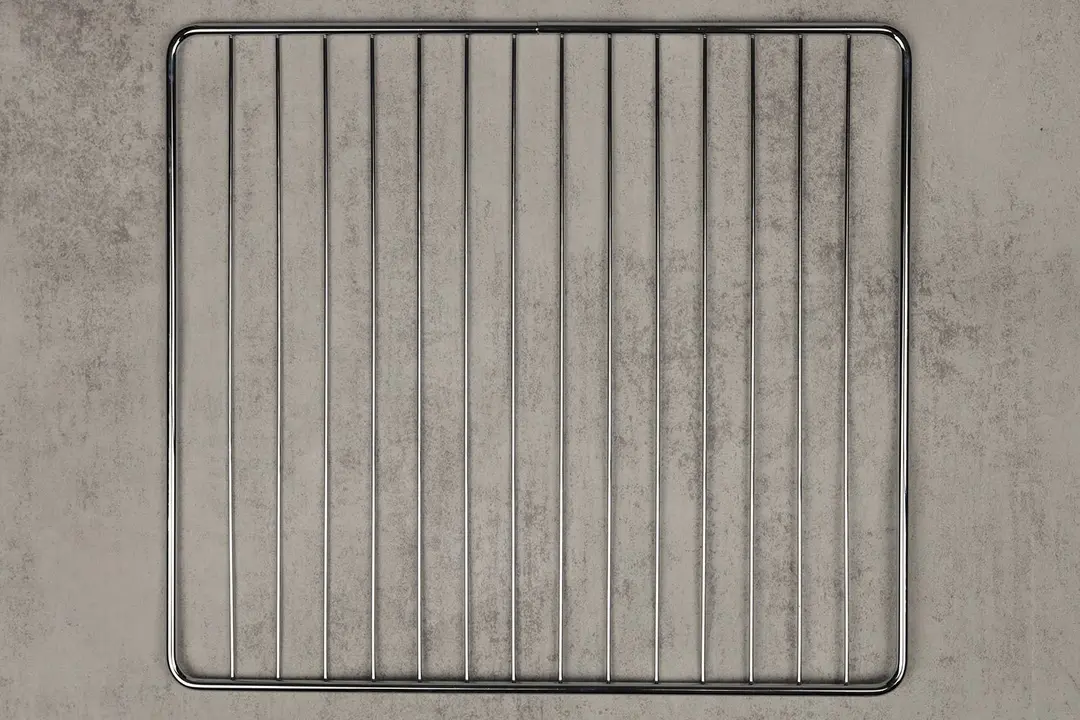 A stainless steel baking rack of the stainless steel Breville BOV450XL Mini Smart Toaster Oven on a grey background.